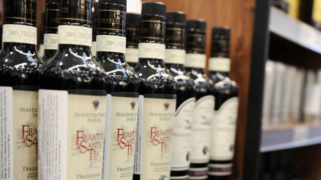 Rad med flaskor med italiensk olivolja i en butikshyllla.