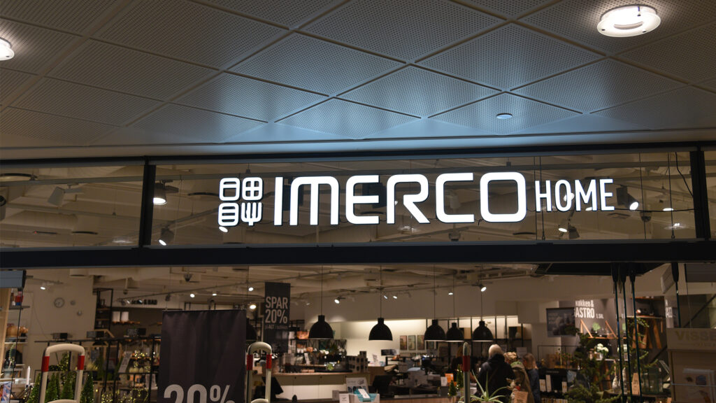 Imerco Home butikkfasade med opplyst logo og interiør med elektroniske hylleetiketter.
