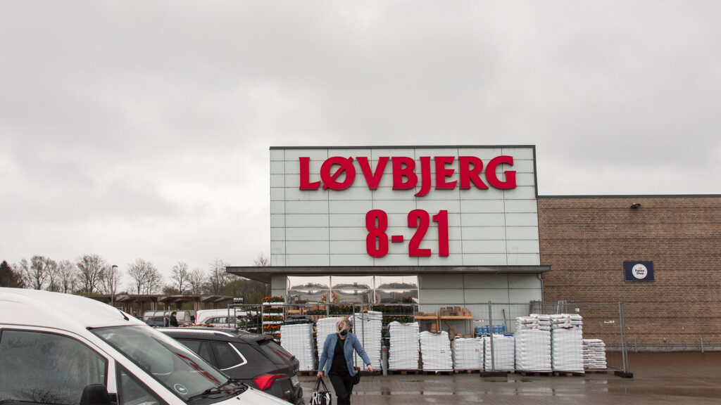 Løvbjerg supermarknad med röd skylt och tider 8-21, samt en kund.