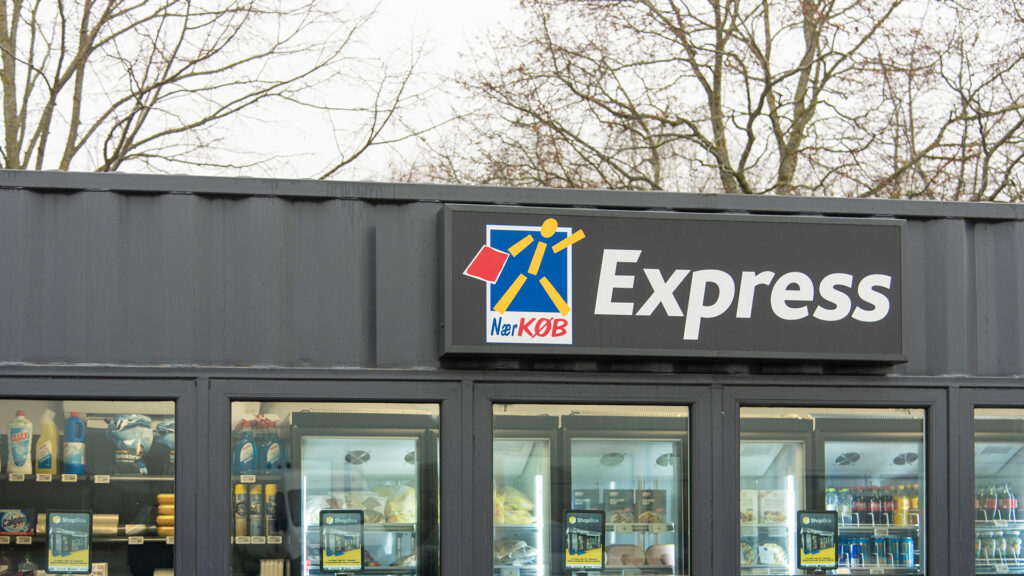 NærKøb Express skylt med logotyp på en obemannad butiksfasad.