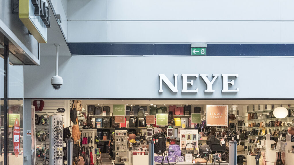 Fasad av NEYE-butik med skylt och ett brett utbud av väskor.