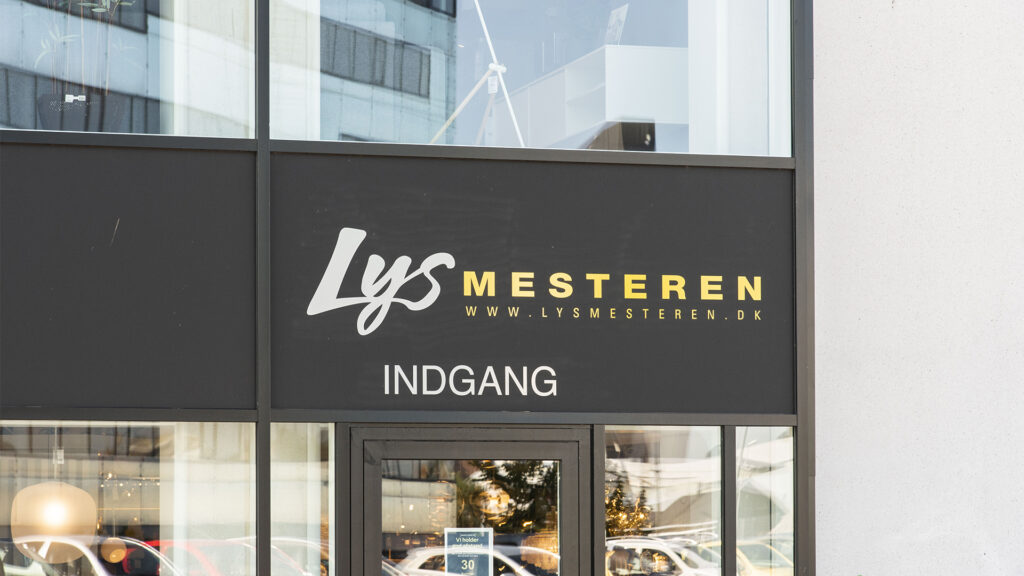 Außenansicht des Lysmesteren Geschäfts mit Schild "Indgang" und der Website.