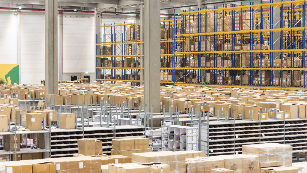 Lagerhalle von Hobbii mit vielen Kartons und Regalen für effiziente Kommissionierung.