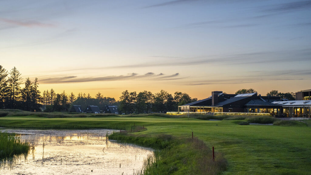 HimmerLand resort og golfbane med sø ved solnedgang.