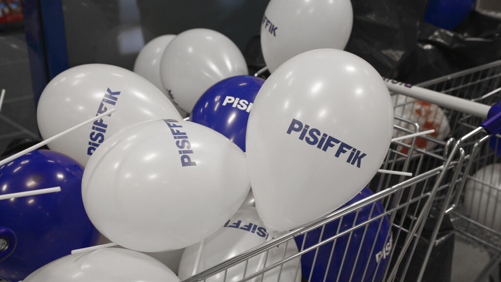 Blaue und weiße Pisiffik-Ballons in einem Einkaufswagen, der auf effiziente Logistik hinweist.