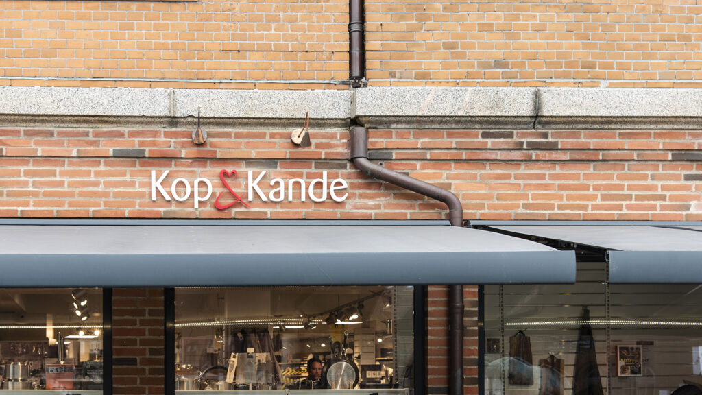 Außenansicht des Kop & Kande Geschäfts in Nykøbing Mors mit digitaler Beschilderung.