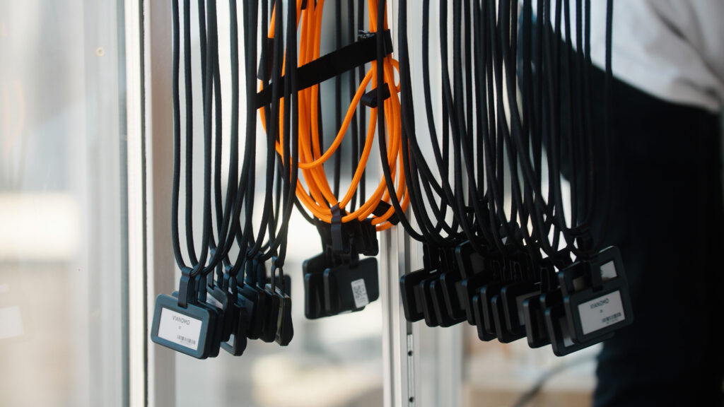 Digitale navneskilte fra Vianomo hænger på en række, klar til brug.